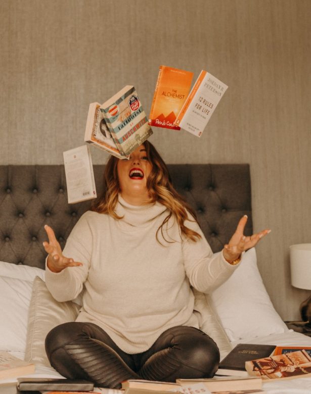 Digital Marketing Consultant & SEO Specialist Aoibhinn Cullen from The OG Marketing Agency sat on a bed throwing books in the air